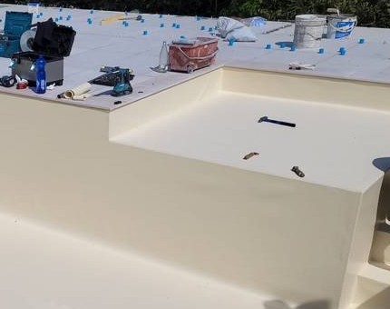 Scalino della piscina con il rivestimento color crema appena posato e gli attrezzi sul bordo