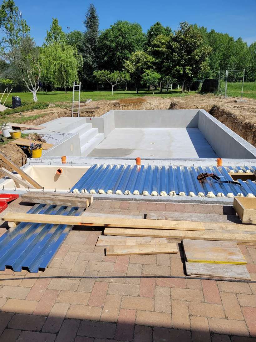 Vasca della piscina in cemento armato completata, con gli scalini d'ingresso